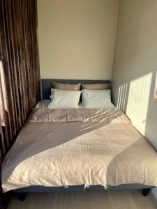 ein großes Bett in einem Schlafzimmer mit einer Bettdecke darauf in der Unterkunft Modern apartment ONLY 5 minutes from City Centre in Bergen