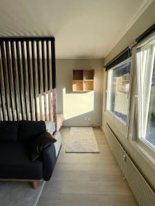 sala de estar con sofá y 2 ventanas en Modern apartment ONLY 5 minutes from City Centre, en Bergen