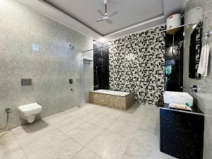 y baño con bañera, aseo y ducha. en The White Oak Corbett Spa & Resort en Rāmnagar