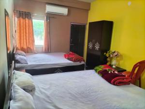 um quarto com três camas e uma janela em Hotel Shobha and Tent House em Patrātu