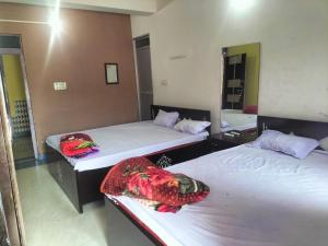 two beds in a room with two beds sidx sidx sidx at Hotel Shobha and Tent House in Patrātu