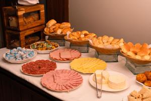 einen Tisch mit verschiedenen Brotsorten und Kuchen in der Unterkunft Gran Executive Hotel in Uberlândia