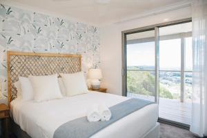 um quarto com uma cama e uma grande janela em Flaxton residence with spectacular coastal views em Montville