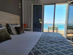 een slaapkamer met een bed en uitzicht op de oceaan bij Salt Life in Dhërmi