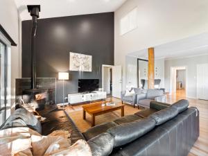 a living room with a leather couch and a fireplace at Abundance in Margaret River Town