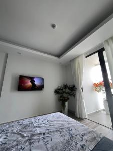 1 dormitorio con 1 cama y TV en la pared en Studio Sofia Center, en Ấp Rạch Mẹo