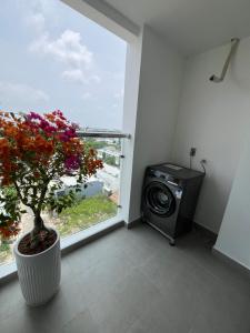 ein Zimmer mit einem Fenster mit einer Anlage und einer Waschmaschine in der Unterkunft Studio Sofia Center in Ấp Rạch Mẹo