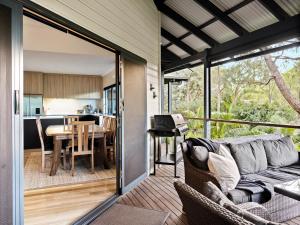 a screened in porch with a couch and a dining room at Abundance in Margaret River Town