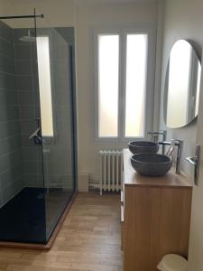 a bathroom with two sinks and a glass shower at Chez Léonine, maison en centre ville in Tours +12 photos
