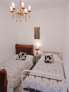 a bedroom with two beds and a chandelier at Les Gites du Mont Ventoux in Bédoin