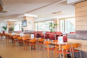 a room with tables and chairs in a building at ALEGRIA Florida Park in Santa Susanna