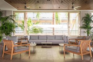 a living room with a couch and chairs and plants at ALEGRIA Florida Park in Santa Susanna