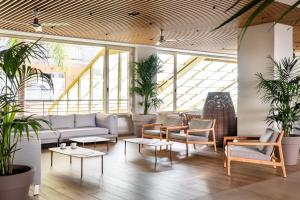 a lobby with couches and tables and plants at ALEGRIA Florida Park in Santa Susanna