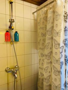 - un rideau de douche avec des papillons dans la salle de bains dans l'établissement Kotoisa saunallinen kaksio!, à Kuopio