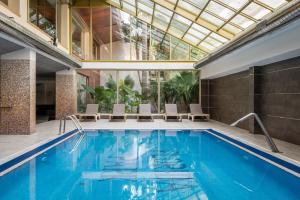 an indoor pool with chairs and a large glass ceiling at ALEGRIA Florida Park in Santa Susanna