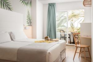 a bedroom with a bed and a desk and a window at ALEGRIA Florida Park in Santa Susanna