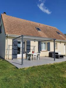 a house with a deck with a table and chairs at maison moderne in Saint-Antonin-de-Sommaire