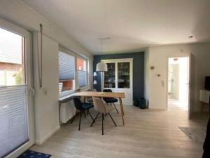 a dining room with a table and chairs in a room at Haus-Seefalke-Bungalow-Achterdeck in Borkum