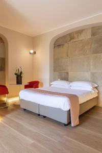 um quarto com uma cama grande e uma cadeira vermelha em Villa Battibecco em Loreto