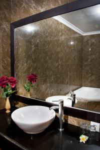 a bathroom with two sinks and a large mirror at Sindhu Mertha Suite in Sanur