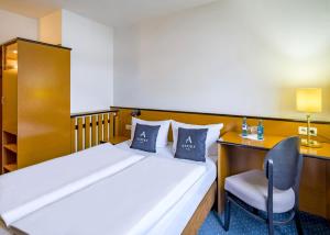 a bedroom with a bed and a desk and a chair at Aspire Frankfurt Airport, Trademark Collection by Wyndham in Rüsselsheim +39 photos