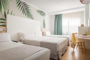 a hotel room with two beds and a desk at ALEGRIA Florida Park in Santa Susanna