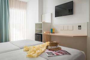 a room with a bed with a tv and a stuffed animal at ALEGRIA Florida Park in Santa Susanna