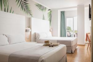 a hotel room with two beds and a balcony at ALEGRIA Florida Park in Santa Susanna
