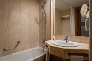 a bathroom with a sink and a tub and a mirror at ALEGRIA Florida Park in Santa Susanna
