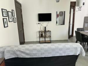 Studio flat 7A في Hamrun: غرفة نوم بسرير وتلفزيون على جدار