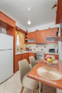 una cucina con tavolo in legno e frigorifero bianco di Niki's House a Gournes