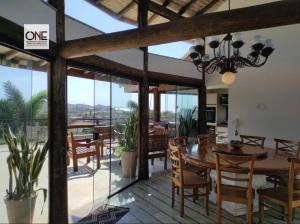 a dining room with a wooden table and glass doors at Casa espetacular na praia Brava in Búzios