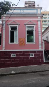 un bâtiment rose sur le côté d'une rue dans l'établissement Pousada Barão de Santa Helena, à Juiz de Fora