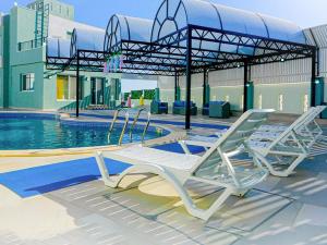 a pool with two lounge chairs next to a swimming pool at Gerasa Breeze resort in Rujm al Miḑmār