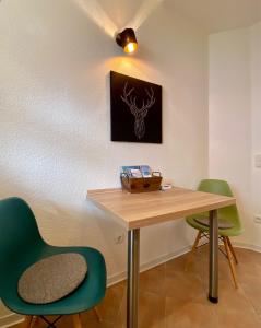une chambre avec une table et deux chaises vertes dans l'établissement Relax-Fewo-Rösch, à Trechtingshausen