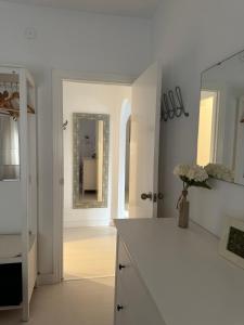 a white kitchen with a counter and a mirror at Son de Mar 1 in Bolonia