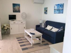 ein Wohnzimmer mit einem blauen Sofa und einem Tisch in der Unterkunft Une fenêtre sur la mer in Le Gosier
