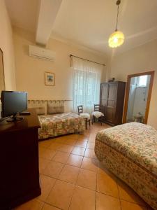 um quarto de hotel com duas camas e uma televisão em Agriturismo Le Macine-Poggio Cono em Teramo