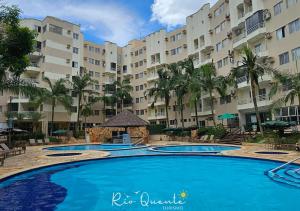 a pool in front of a large apartment building at Thermas Paradise Residence in Rio Quente