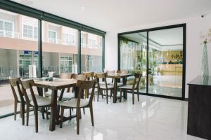 a dining room with tables and chairs and windows at Peppery Hills in Chiang Mai