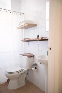 a white bathroom with a toilet and a sink at Casona El Resguardo - Solo Adultos in Río Blanco