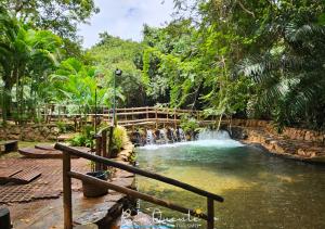 a pool of water with a waterfall in a park at Thermas Paradise Residence in Rio Quente