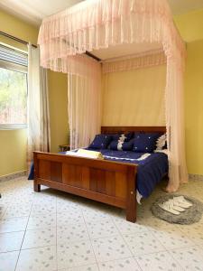 1 dormitorio con 1 cama con dosel en Dangotte Residence Lounge en Kabale