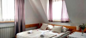 a bedroom with two beds and two windows at Pokoje u Doroty in Zakopane