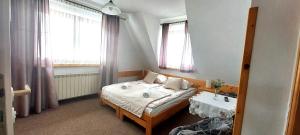 1 dormitorio con cama, mesa y ventanas en Pokoje u Doroty - w bliskości z naturą en Zakopane