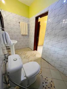 a bathroom with a white toilet and a mirror at Dangotte Residence Lounge in Kabale