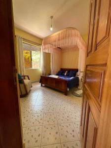 1 dormitorio con 1 cama con dosel en Dangotte Residence Lounge en Kabale
