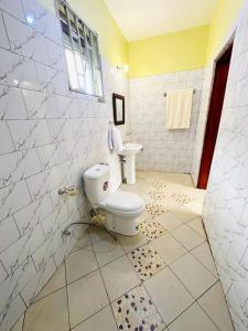 a bathroom with a toilet and a sink at Dangotte Residence Lounge in Kabale
