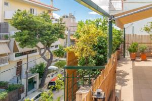 um apartamento com varanda com cerca e árvores em The HostMaster Ethnic Touch Feel Studio em Atenas