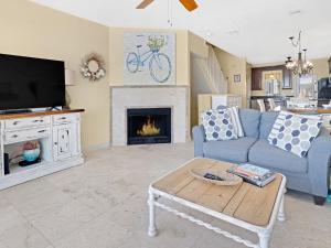 a living room with a blue couch and a fireplace at Seagrove Dunes #1 in Seagrove Beach